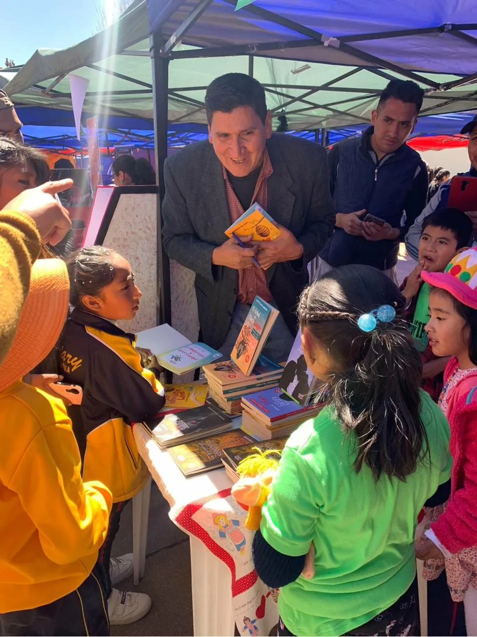 David Vildoso signing books for children at a book fair